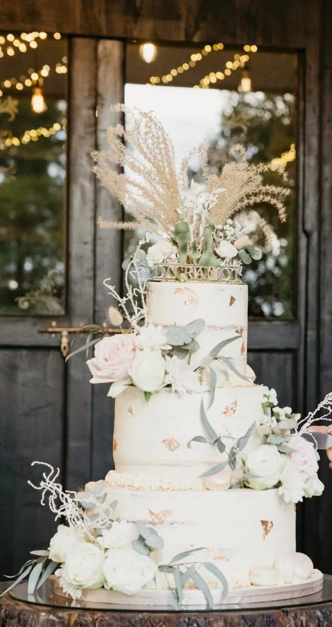 Ivory wedding cake with gold details and white roses